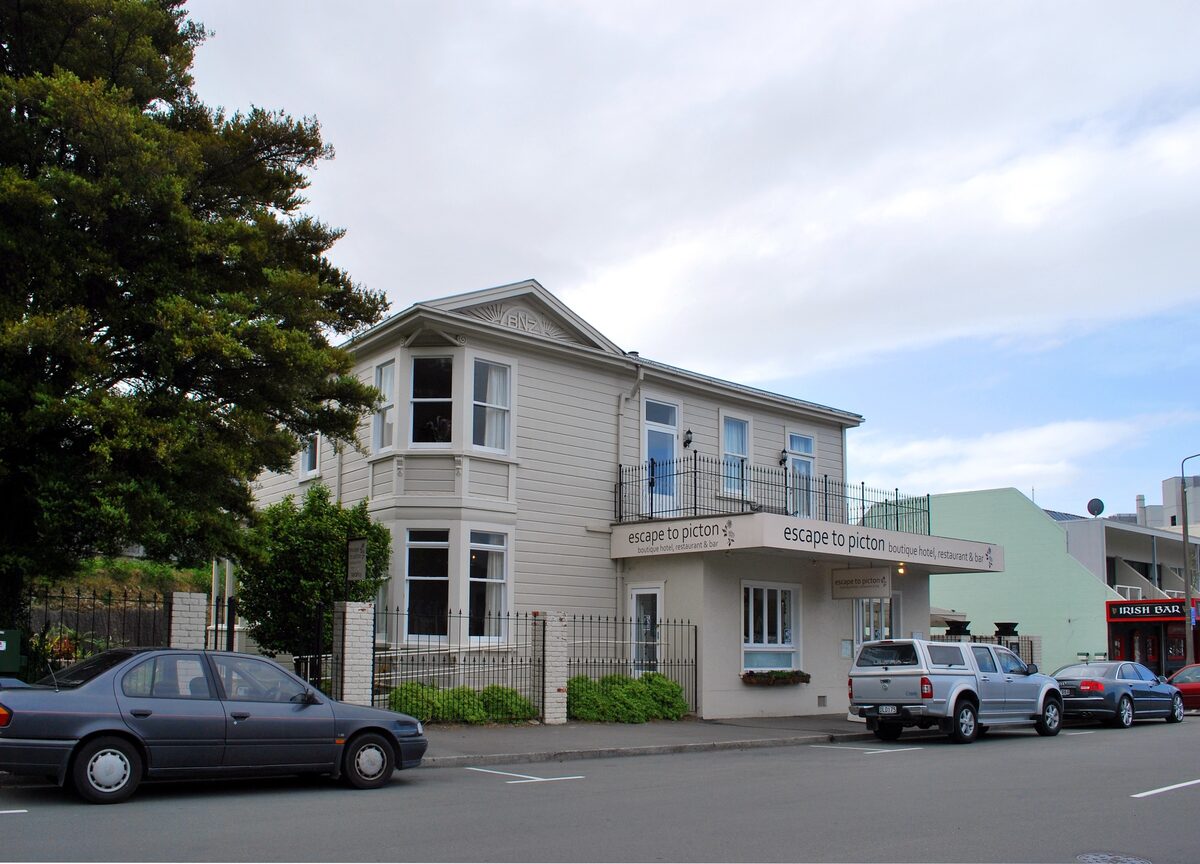 Cream weatherboard villa with an Escape to Picton sign on its verandah
