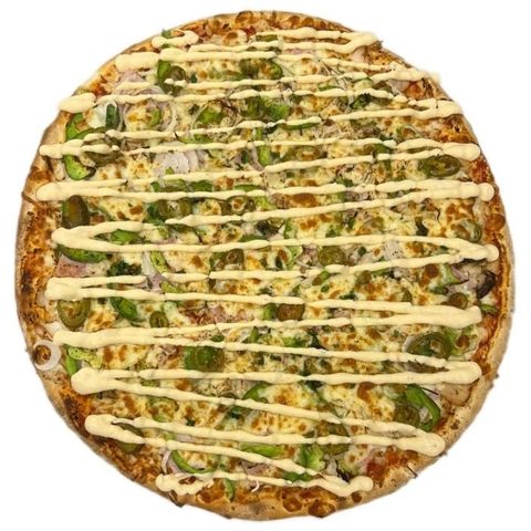 A whole baked pizza topped with green peppers and a pale sauce drizzle on a white background.